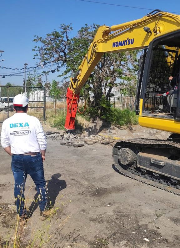Operario de DEXA Chile junto a una excavadora Komatsu con martillo hidráulico