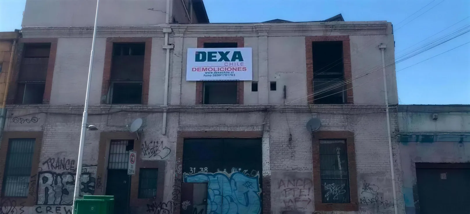 Edificio con el letrero de DEXA Demoliciones antes de la faena