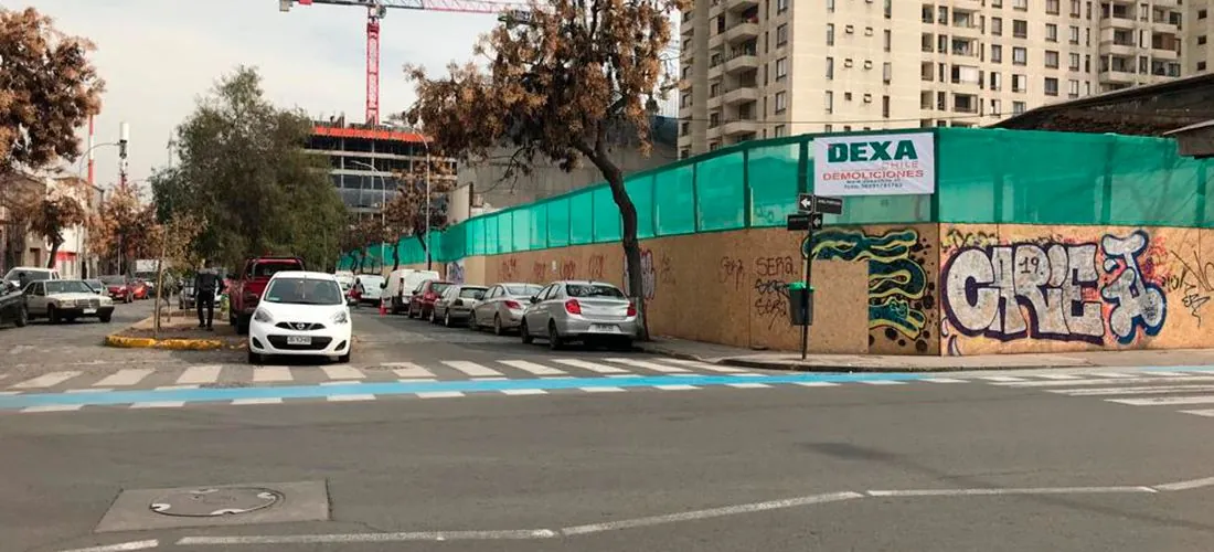 Cierre de obra de DEXA en una esquina de Santiago, con la torre grúa al fondo